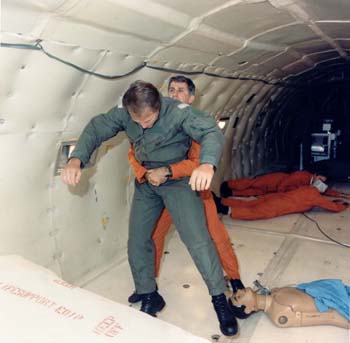 S88-44346.jpg - Mike Fox performing the Heimlich maneuver on Dr. Phil Stepaniak in the KC-135 (1988) 