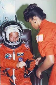 STS-45 Commander Charlie Bolden being suited up by McDougle at KSC