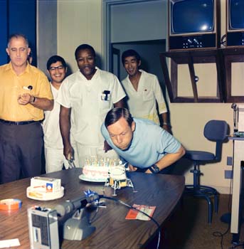 Astronaut Neil Armstrong blowing out candles on his birthday cake in the Lunar Receiving Laboratory Crew Reception Area after the Apollo 11 mission.