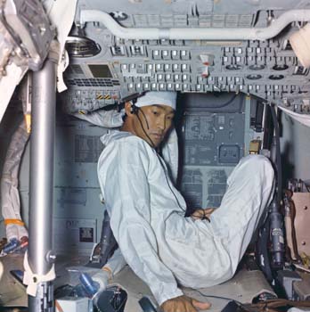 Landing and Recovery Division Systems Engineer John K. Hirasaki removing equipment and decontaminating of the interior of the Apollo 11 spacecraft inside the Lunar Receiving Lab.