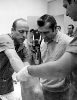 Astronauts Pete Conrad and Dick Gordon inspecting lunar rocks brought back from the Moon during their Apollo 12 mission.