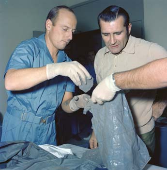 Astronauts Pete Conrad and Dick Gordon inspecting lunar rocks brought back from the Moon during their Apollo 12 mission.