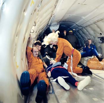 Astronaut Rhea Seddon practicing on Resusci Anne, the cardiopulmonary resuscitation (CPR) training mannequin, during a Zero G flight on the KC-135.  Terry Slezak can be seen on the right with the camera.