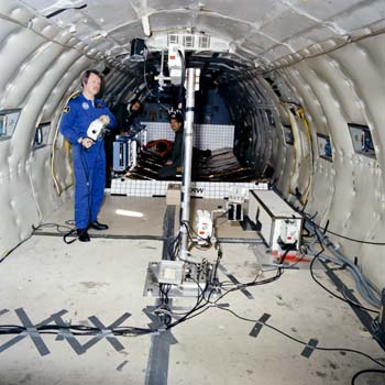 Terry Slezak in KC-135 Zero G aircraft with the TRW solar array panels.