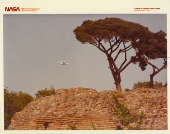 The Space Shuttle Enterprise on top of the Shuttle Carrier Aircraft on the way to the Paris Air Show in 1983.  Terry Slezak and his wife happened to see the docked vehicles and took this photo of the flight over the ruined walls of the Roman Forum while vacationing in Rome Italy.