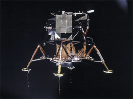 The Apollo 11 Lunar Module is photographed in lunar orbit from the Command and Service Modules.