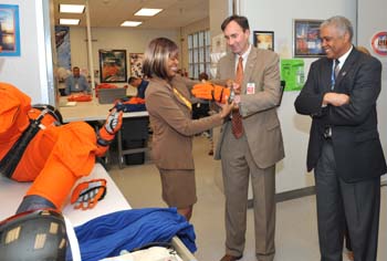 Congressman Pete Olson visits USA/FCE. McDougle assisted him donning a glove as Willard Jones watched. 