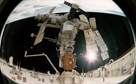 View of Mir docked to the space shuttle, as seen from the shuttle's aft flight deck windows, down the payload bay.