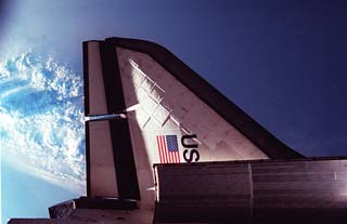 Port tail of shuttle with Earth below
