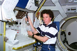 STS-71 mission specialist Ellen Baker works with specimens taken during medical experiments in the Spacelab module.