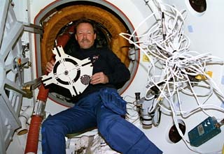 Astronaut Robert L. Gibson, STS-71 mission commander, holds the docking target which was removed earlier from the Kristall (materials science module) on Mir. 