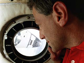 Astronaut Jay Apt is looking at the orbiter Atlantis from the Mir flight engineer's cabin.