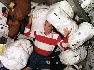 Wilcutt surrounded by water transfer bags in the Atlantis's middeck