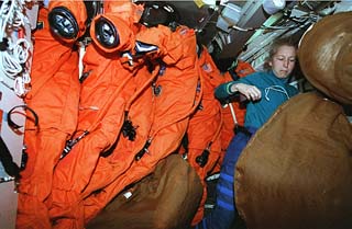 Ivins stows launch and entry suits on shuttle