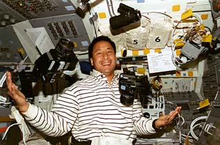STS-84 Mission Specialist Ed Lu juggles 70mm and 35mm cameras