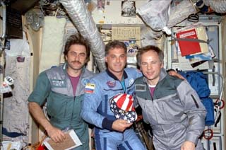 Wolf (center) poses with his new crewmates Mir 24 flight engineer Pavel Vinogradov (left) and commander Anatoly Solovyev (right).