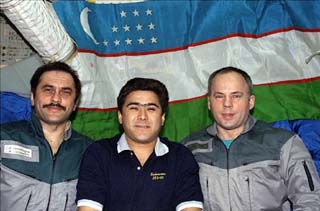 Vinogradov, Sharipov, and Solovyev float before an Uzbeck flag hanging on the Base Block