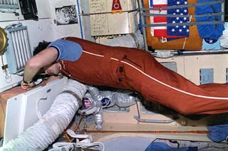 Mir 18 commander Vladimir N. Dezhurov performing in-flight maintenance in the Core module of the Mir space station.